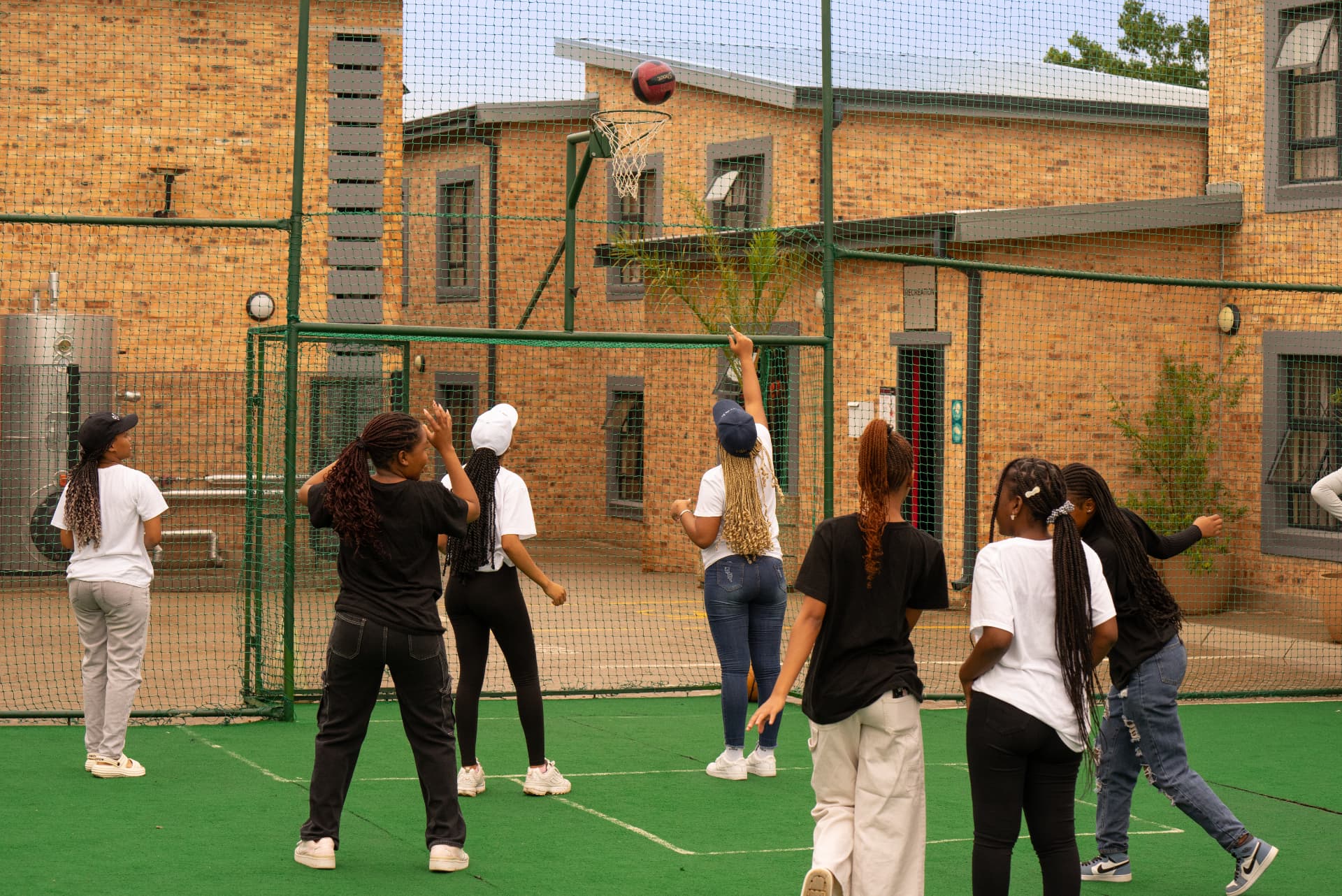 Students playing netball on the on-site astro sports court
