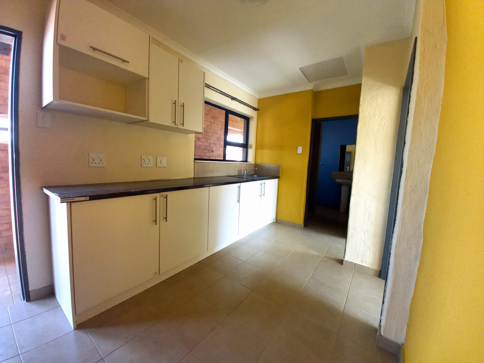 Shared apartment kitchen with fitted cupboards and counter