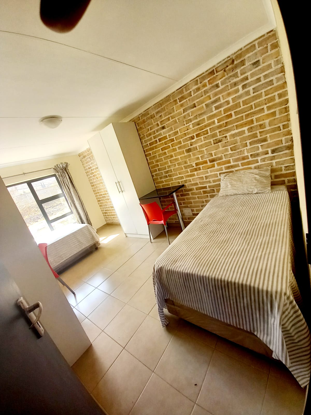 Twin bedroom with two beds, study desks and built-in cupboards